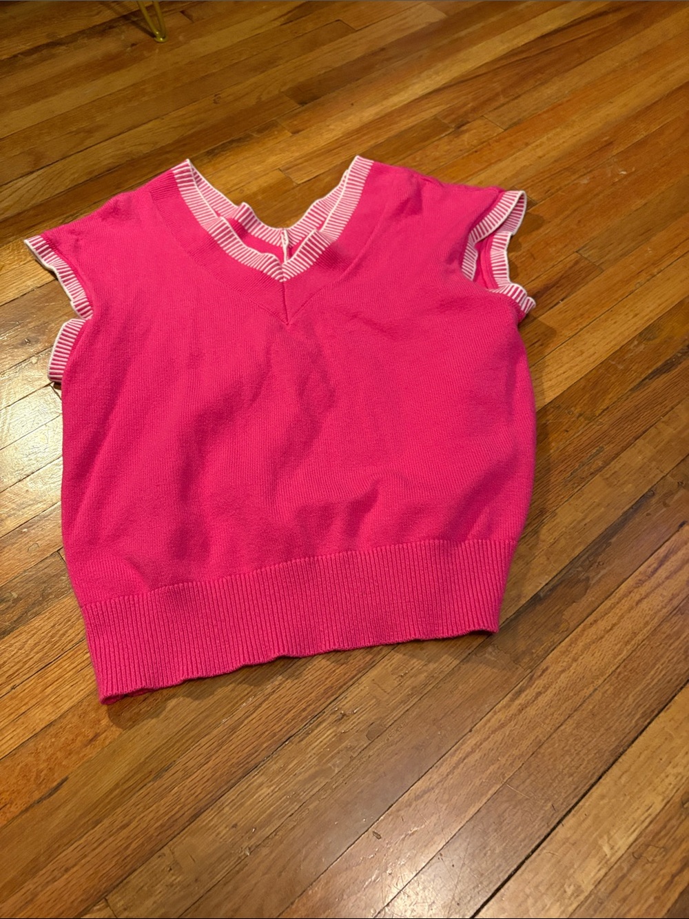 Pink sweater vest with white striped trim